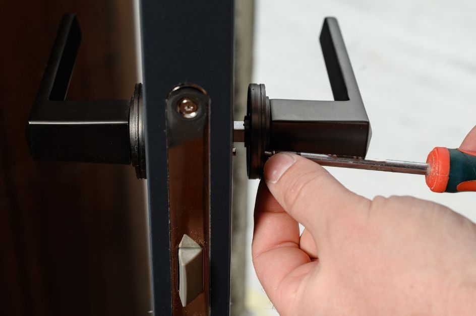 A locksmith repairing a door lock